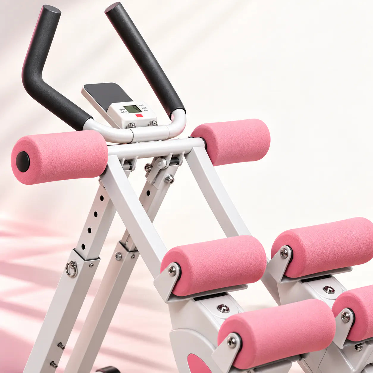 Gros plan sur les poignées, l’écran et les rouleaux roses de l’Ab Trainer